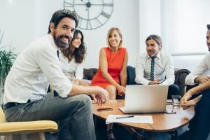 joyful businessman with his coworkers 1 scaled e1748266107669
